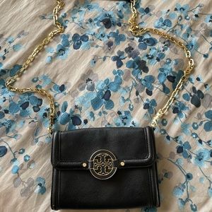 Tory burch crossbody with gold chain and leather on top of chain.